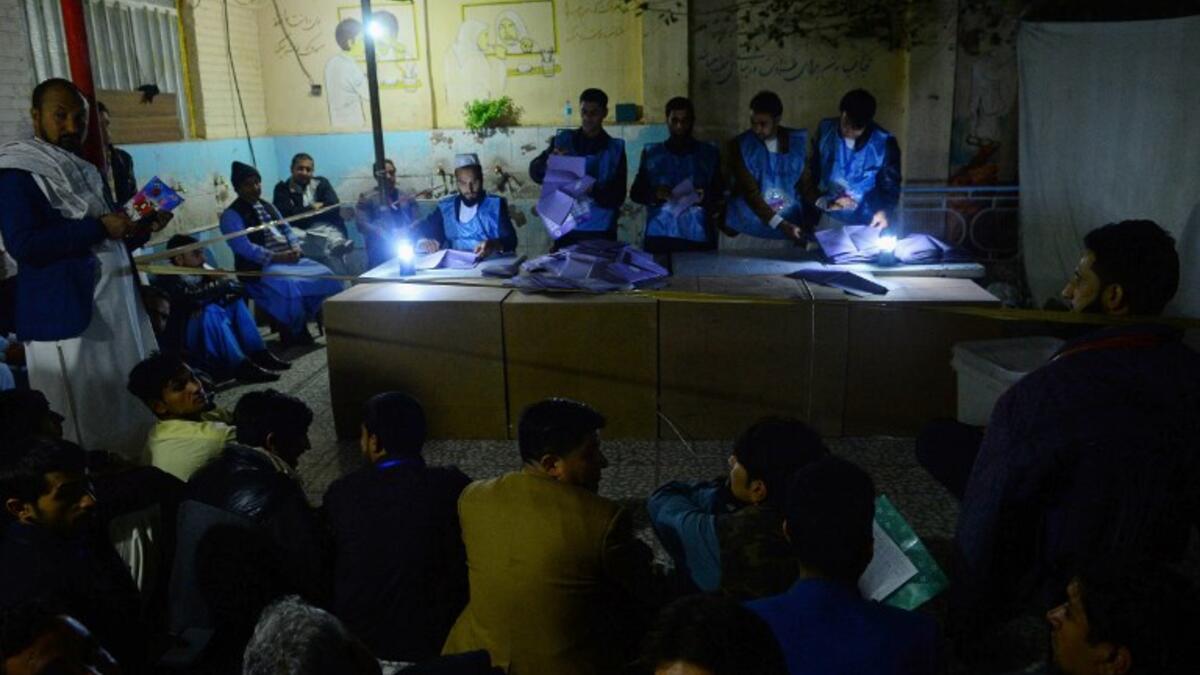 In this photo taken on October 20, 2018, Afghan Independent Election Commission (IEC) officials count ballot papers at a polling centre for the country's legislative election in Herat province. 
HOSHANG HASHIMI / AFP