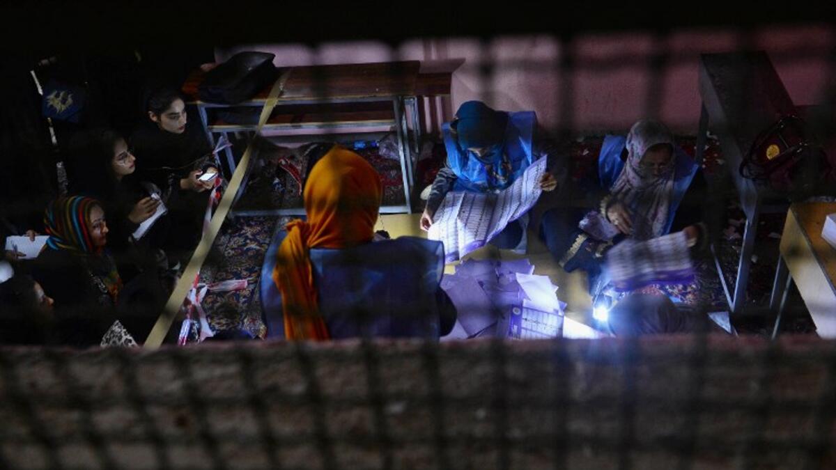 In this photo taken on October 20, 2018, Afghan Independent Election Commission (IEC) officials count ballot papers at a polling centre for the country's legislative election in Herat province. 
HOSHANG HASHIMI / AFP
