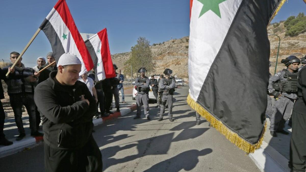 Israeli security forces stand guard as Druze men protest against municipal elections in front of a polling centre in the village of Majdal Shams in the Israeli-annexed Golan Heights on October 30, 2018. (JALAA MAREY / AFP)