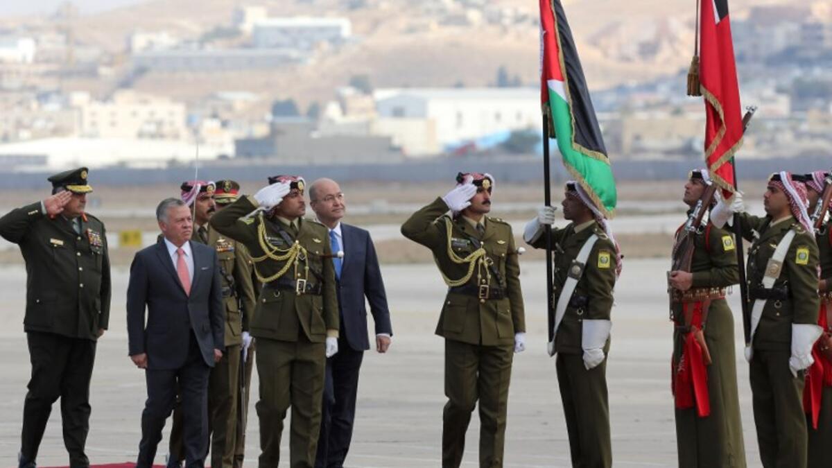 Iraq's President Barham Salih and Jordan's King Abdullah II (L) review an honor guard at Amman's military airport, on November 15, 2018. 
Khalil MAZRAAWI / AFP