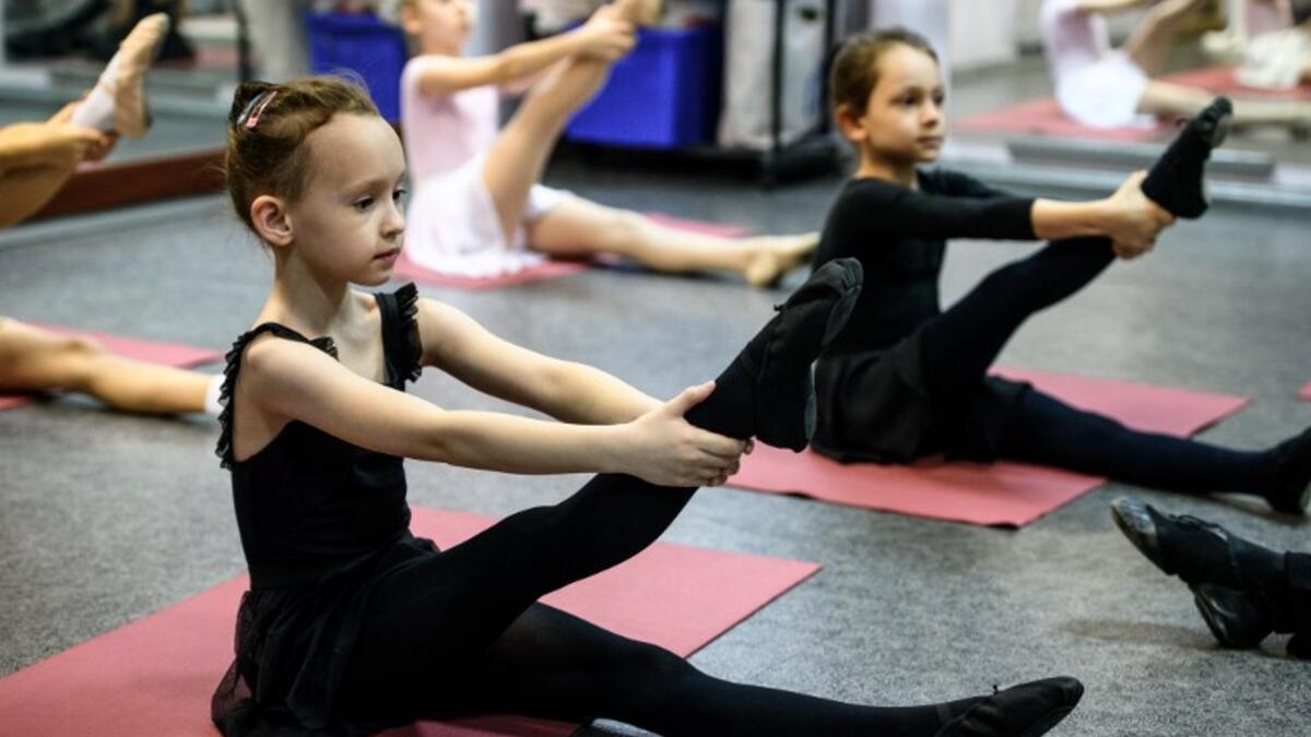 Girls attend a class at a ballet studio in Moscow on November 22, 2018. In a small studio in northern Moscow, parents and grandparents sit in a corridor waiting for children as young as three to finish their ballet class. 
Mladen ANTONOV / AFP