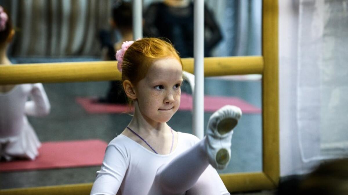 A girl attends a class at a ballet studio in Moscow on November 22, 2018. In a small studio in northern Moscow, parents and grandparents sit in a corridor waiting for children as young as three to finish their ballet class. 
Mladen ANTONOV / AFP