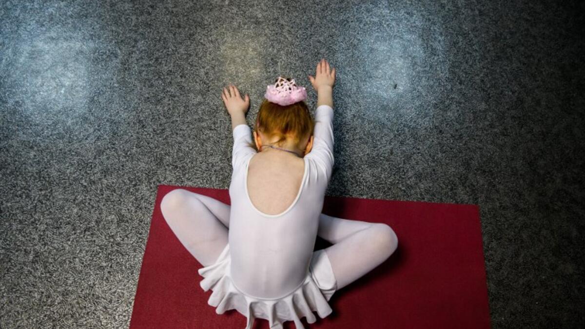 A girl attends a class at a ballet studio in Moscow on November 22, 2018. In a small studio in northern Moscow, parents and grandparents sit in a corridor waiting for children as young as three to finish their ballet class. 
Mladen ANTONOV / AFP