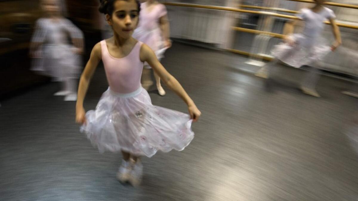 Girls attend a class at a ballet studio in Moscow on November 22, 2018. In a small studio in northern Moscow, parents and grandparents sit in a corridor waiting for children as young as three to finish their ballet class. 
Mladen ANTONOV / AFP