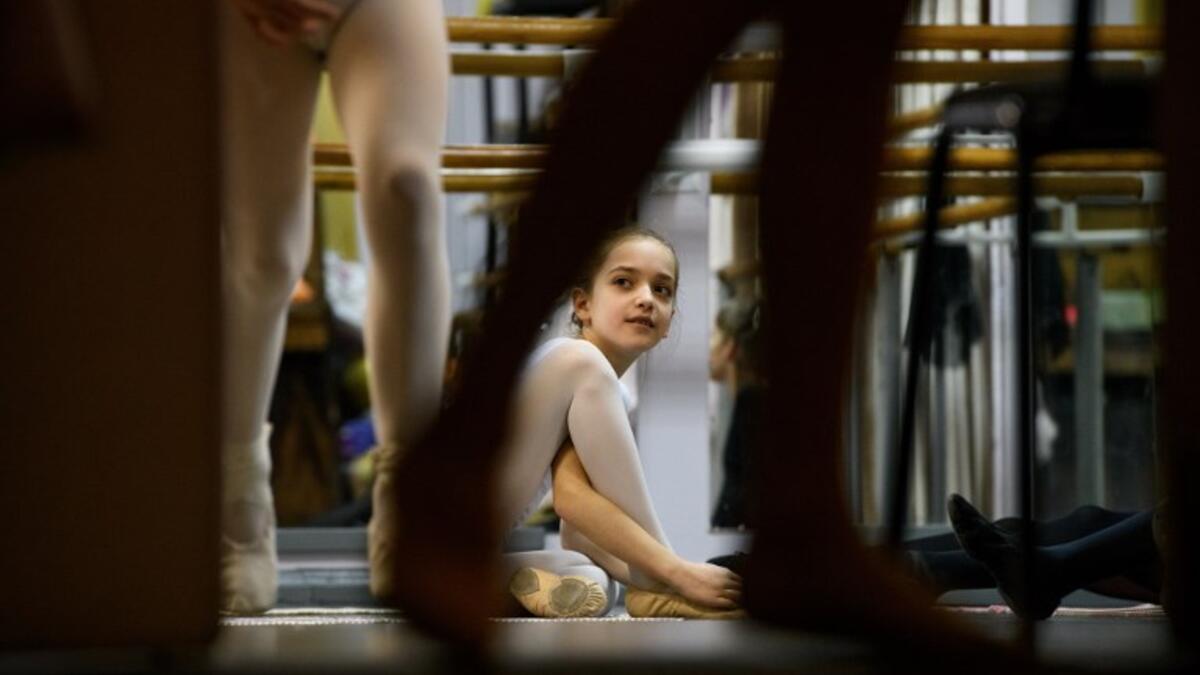 Girls attend a class at a ballet studio in Moscow on November 22, 2018. In a small studio in northern Moscow, parents and grandparents sit in a corridor waiting for children as young as three to finish their ballet class. 
Mladen ANTONOV / AFP