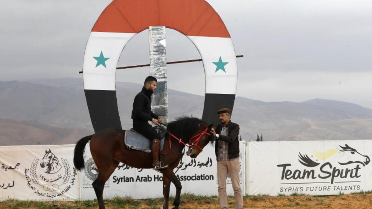A Syrian man prepares to ride a horse at a track in the town of Dimas, west of the Syrian capital Damascus LOUAI BESHARA / AFP