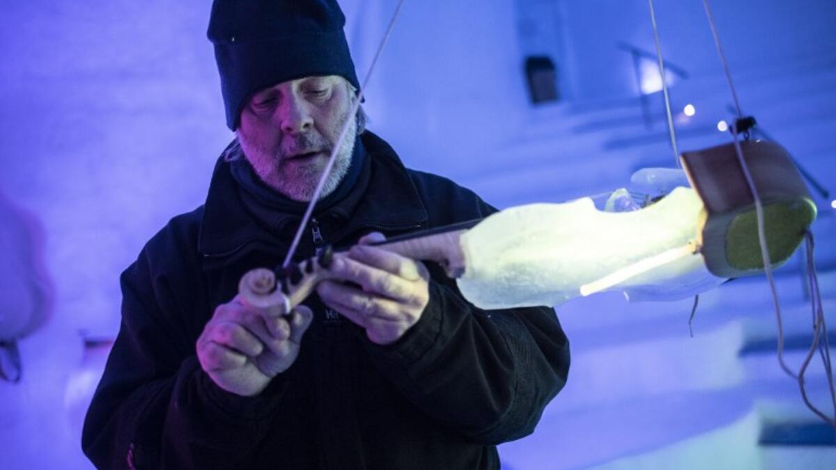 US artist Tim Linhart works on an ice violin in the "Ice Dome" on Presena Galcier, Tonale Pass, near Trento in northern Italy on January 18, 2018. 
Marco BERTORELLO / AFP