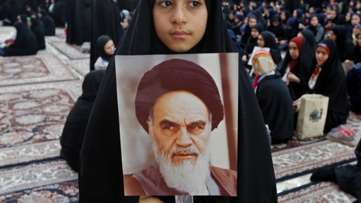 An Iranian girl holds a poster of Iran's late founder of the Islamic Republic, Ayatollah Ruhollah Khomeini. STR / AFP