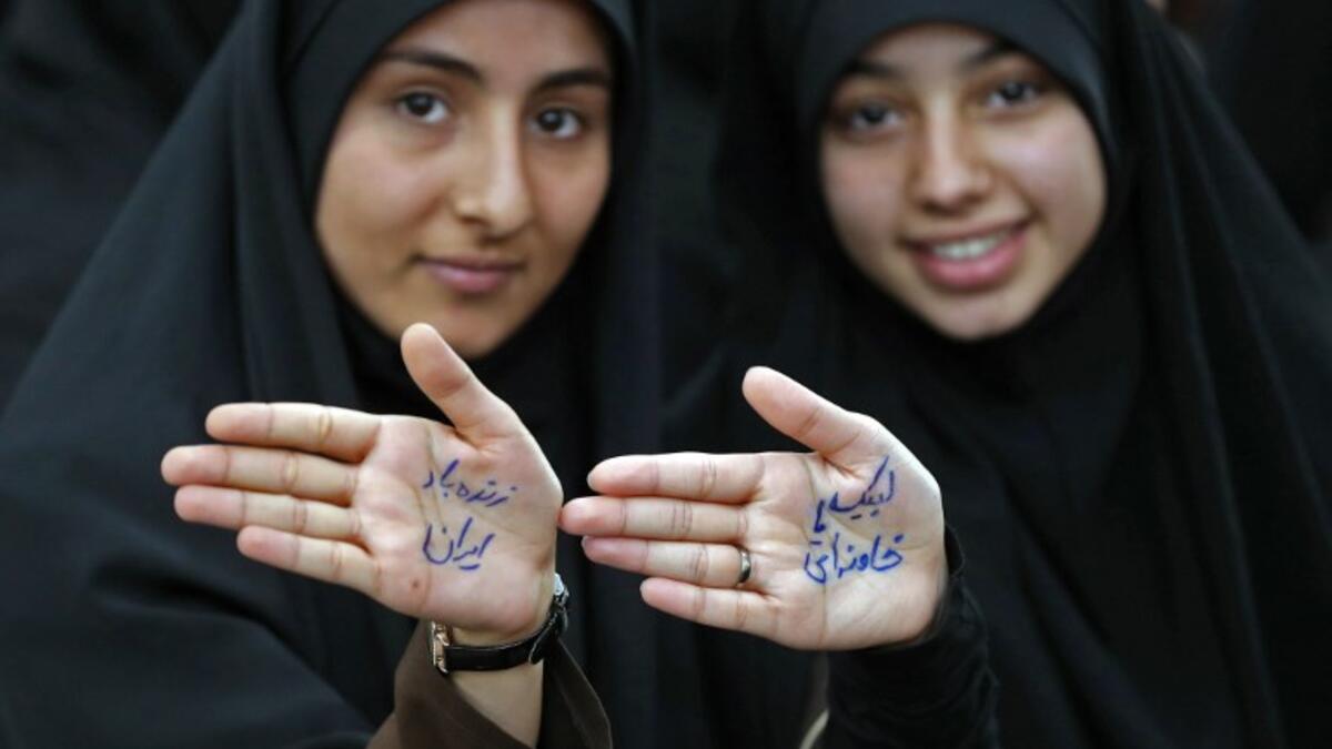 Iranian girls show their hands with a slogan reading in Farsi: "Ready to sacrifice my self for the leader" at the tomb of Iran's late founder of the Islamic Republic, Ayatollah Ruhollah Khomeini. STR / AFP