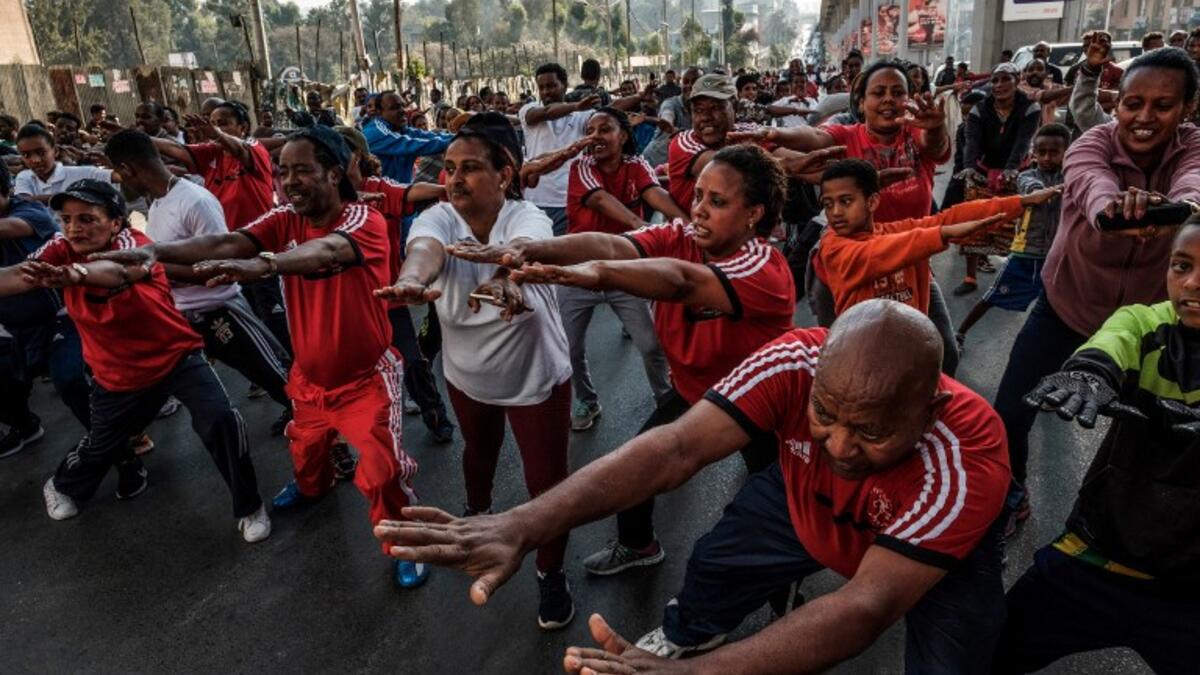 People take part in an exercise on a street in Addis Ababa on February 3, 2019 during the third Car Free Day promoted by local NGOs and the Ethiopian Government to appeal to a healthy life style and a less air pollution of the capital city. 
EDUARDO SOTERAS / AFP