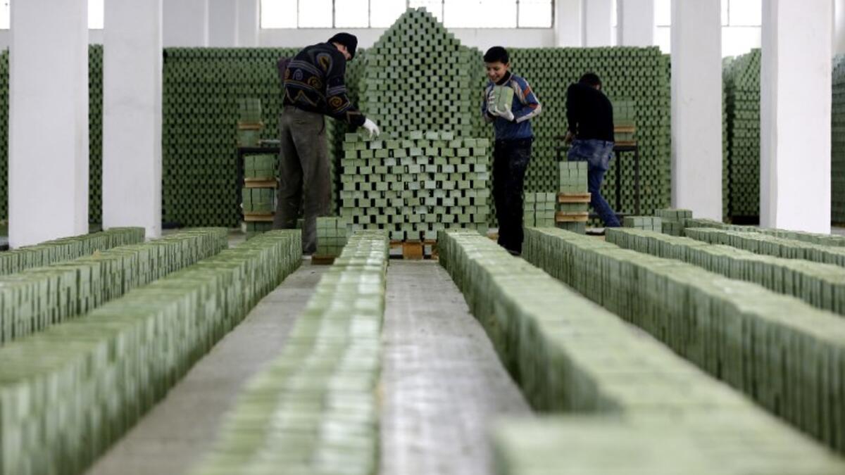 Syrian workers arrange olive soap bars in a factory on the outskirts of Aleppo 
LOUAI BESHARA / AFP