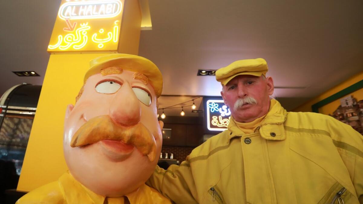 Abu Zakkour, Aleppo's so-called 'yellow man' poses near his statue erected by a local restaurant owner in the northern Syrian city on February 11, 2019. 
LOUAI BESHARA / AFP