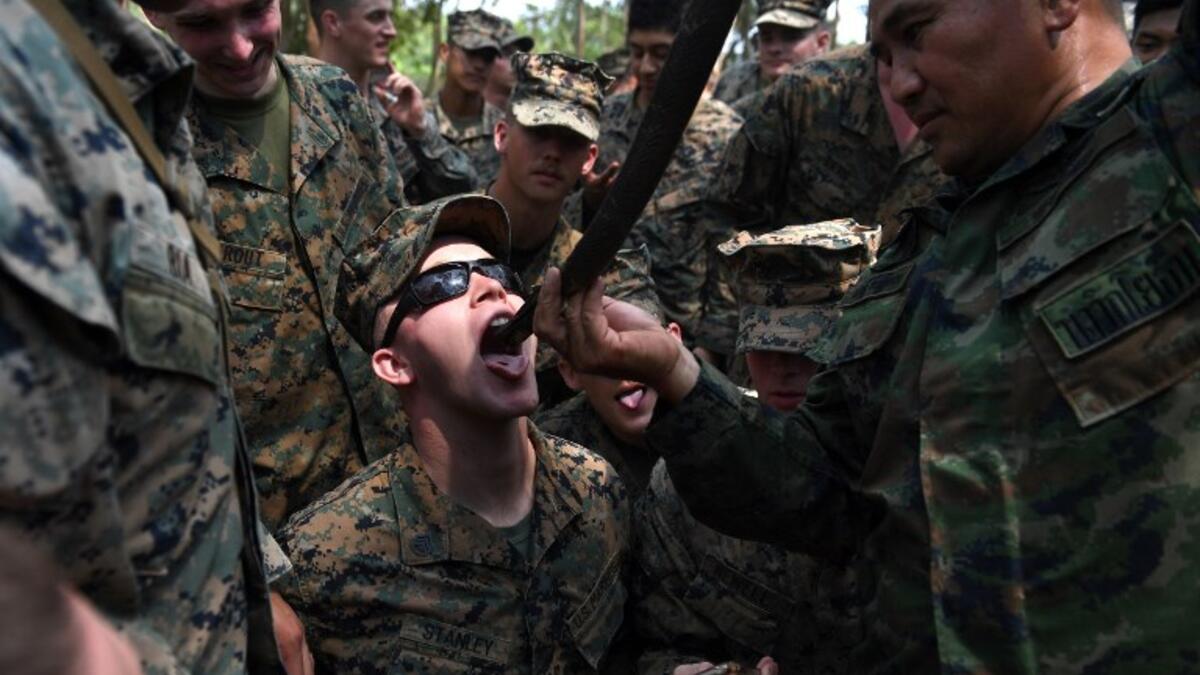 A Thai soldier holds a slaughtered snake while a US Marine drinks its blood during a jungle survival training in the joint 'Cobra Gold' military exercise in Chantaburi province 
Lillian SUWANRUMPHA / AFP