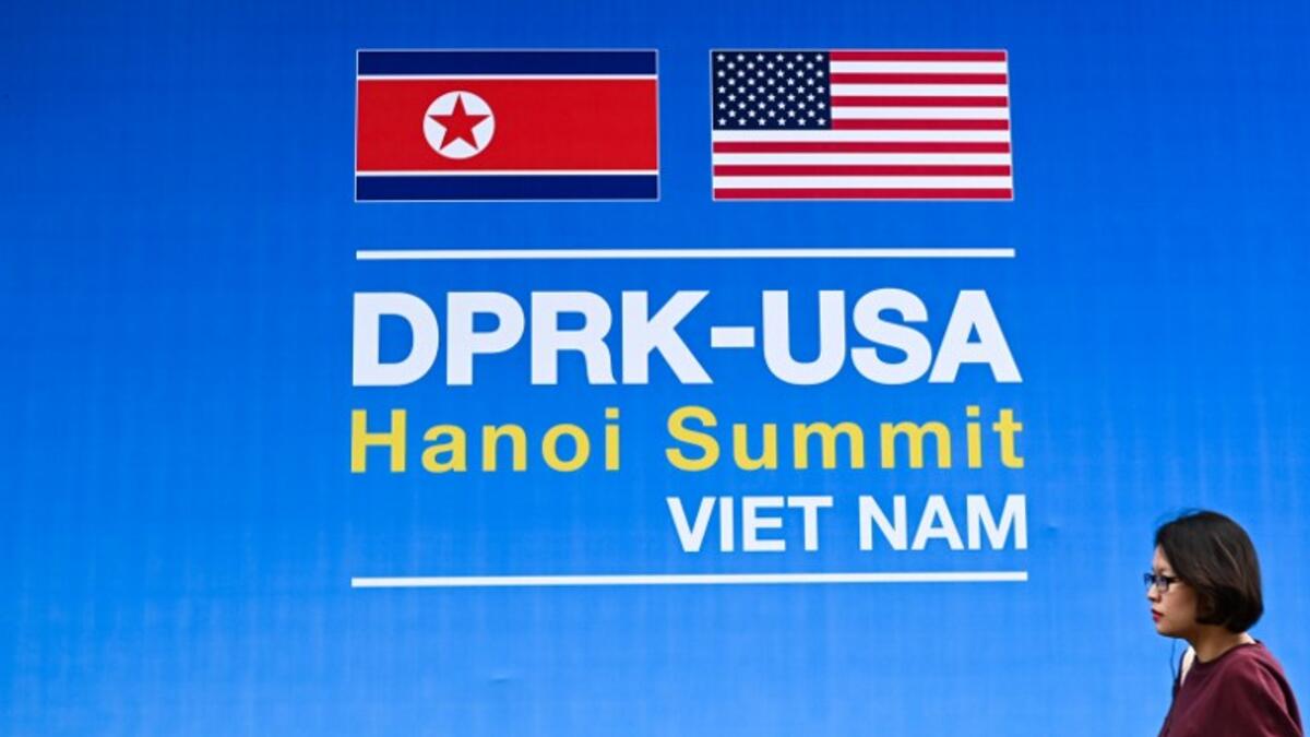 A woman walks past a billboard for the upcoming second summit between US President Donald Trump and North Korean leader Kim Jong Un, in Hanoi on February 24, 2019. 
Jewel SAMAD / AFP