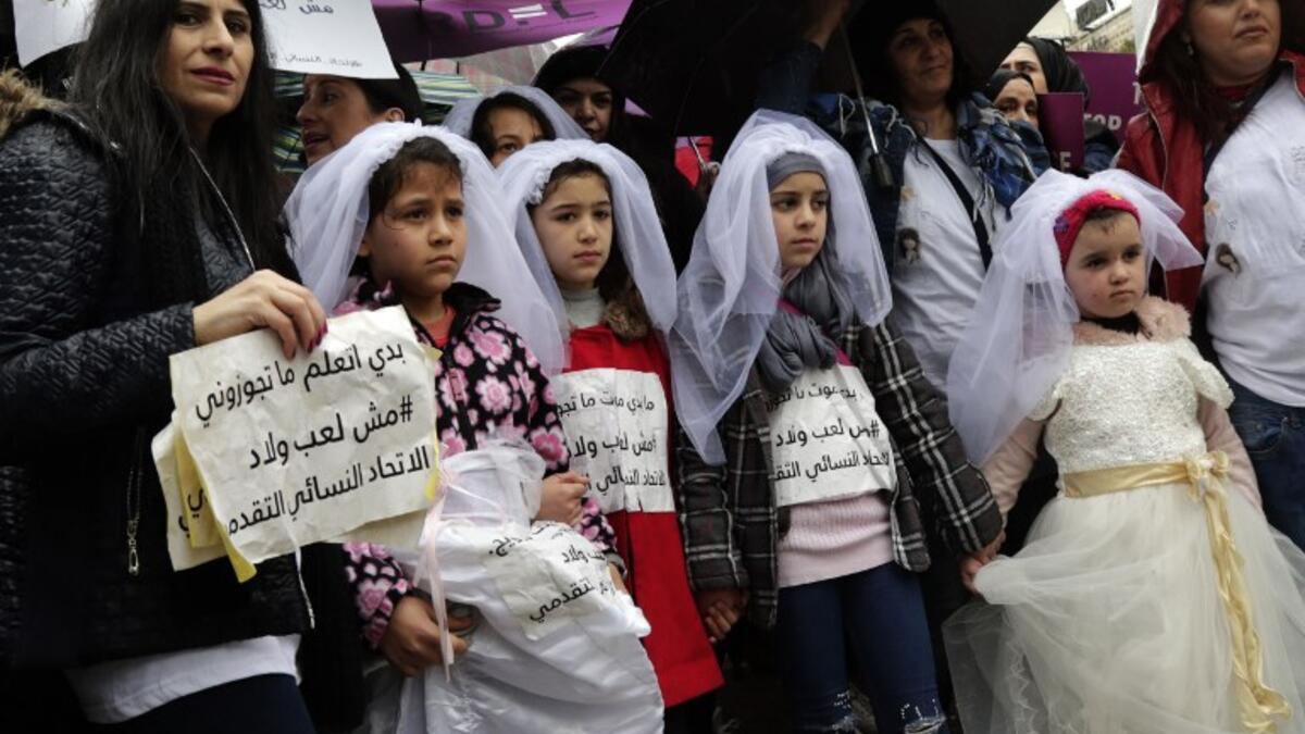 Young Lebanese girls deiguised as brides hold placards as they participate in a march against marriage before the age of 18, in the capital Beirut on March 2, 2019. 
ANWAR AMRO / AFP