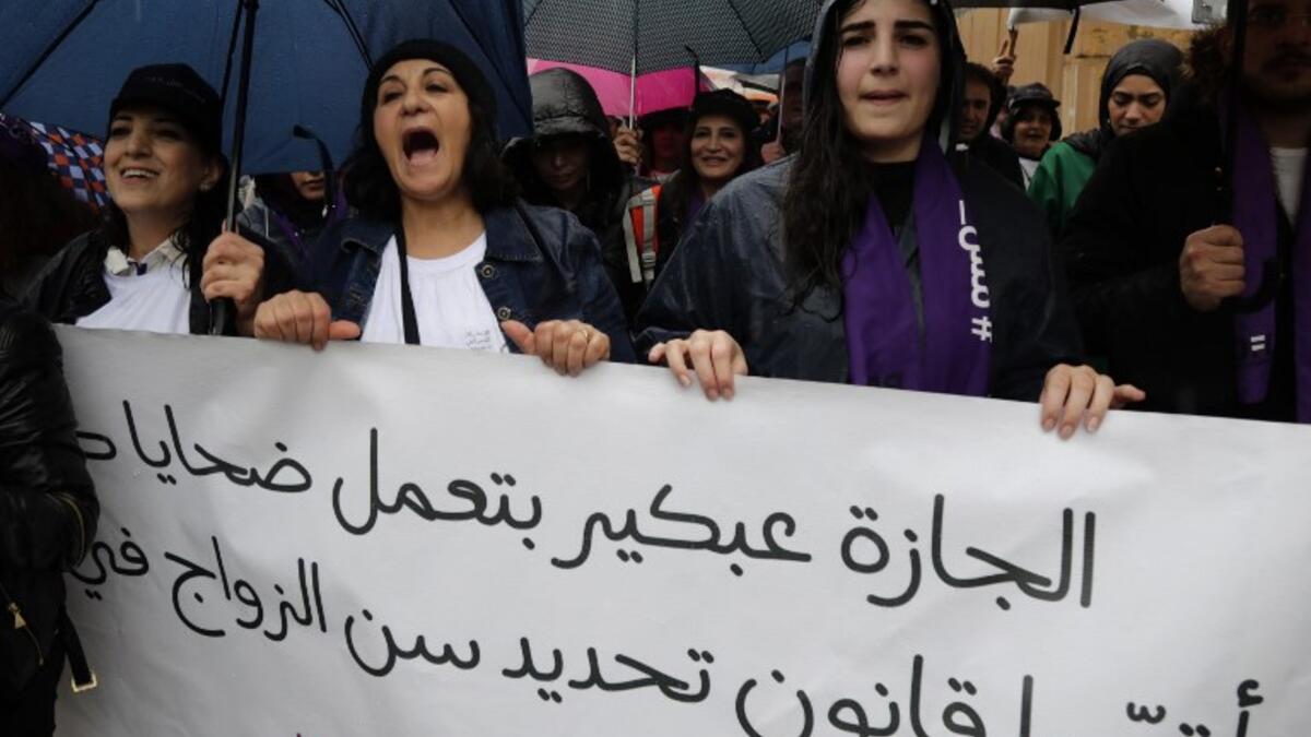 Lebanese demonstrators hold a banner as they participate in a march against marriage before the age of 18 in the capital Beirut on March 2, 2019. The banner in Arabic reads " Early marriage makes victims, change the law". 
ANWAR AMRO / AFP
