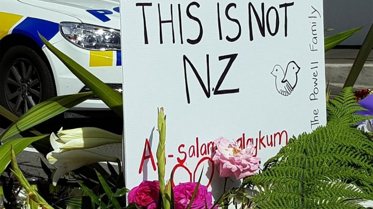 A message is seen as residents pay their respects by placing flowers for the victims of the mosques attacks in Christchurch 
Glenda KWEK / AFP
