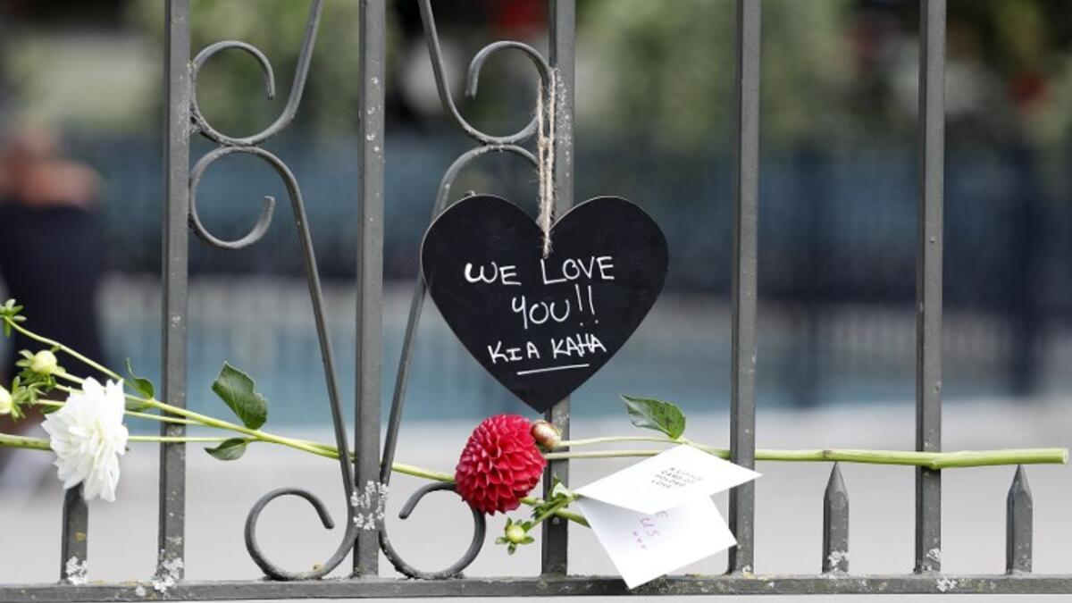 A flower is placed on the railing with a message for the victims of the mosques attacks at the Botanical Garden in Christchurch 
Tessa BURROWS / AFP