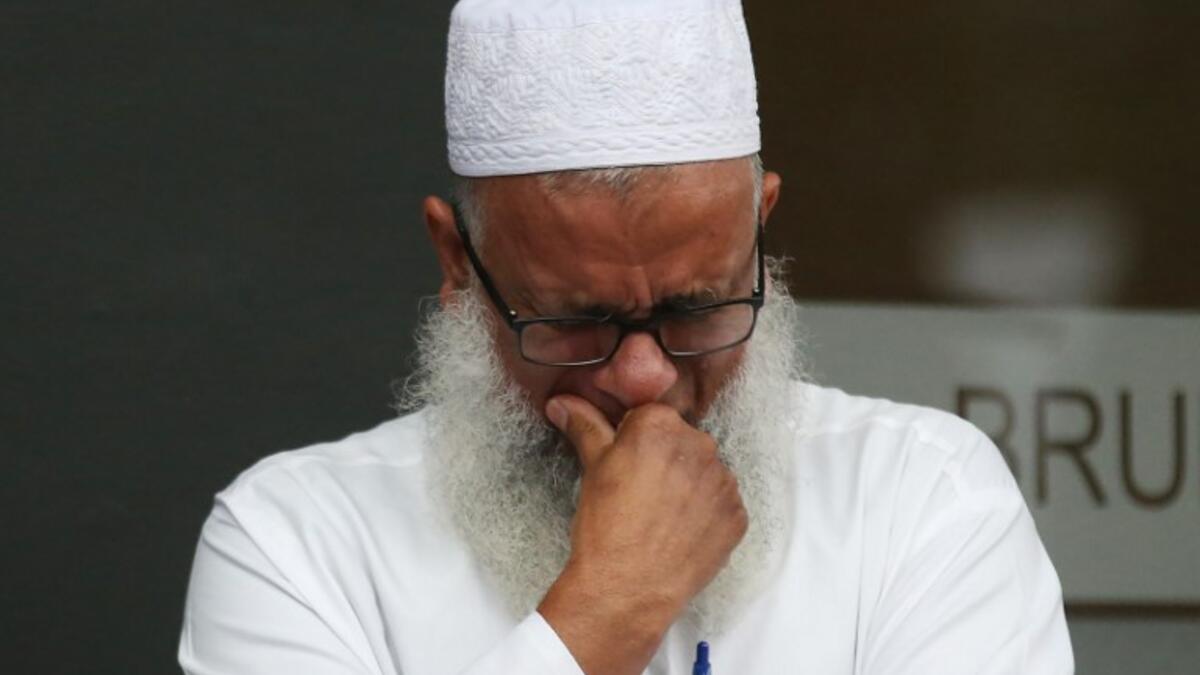 A man reacts as people arrive to pay their respects in front of floral tributes for victims of the March 15 mosque attacks, in Christchurch 
DAVID MOIR / AFP