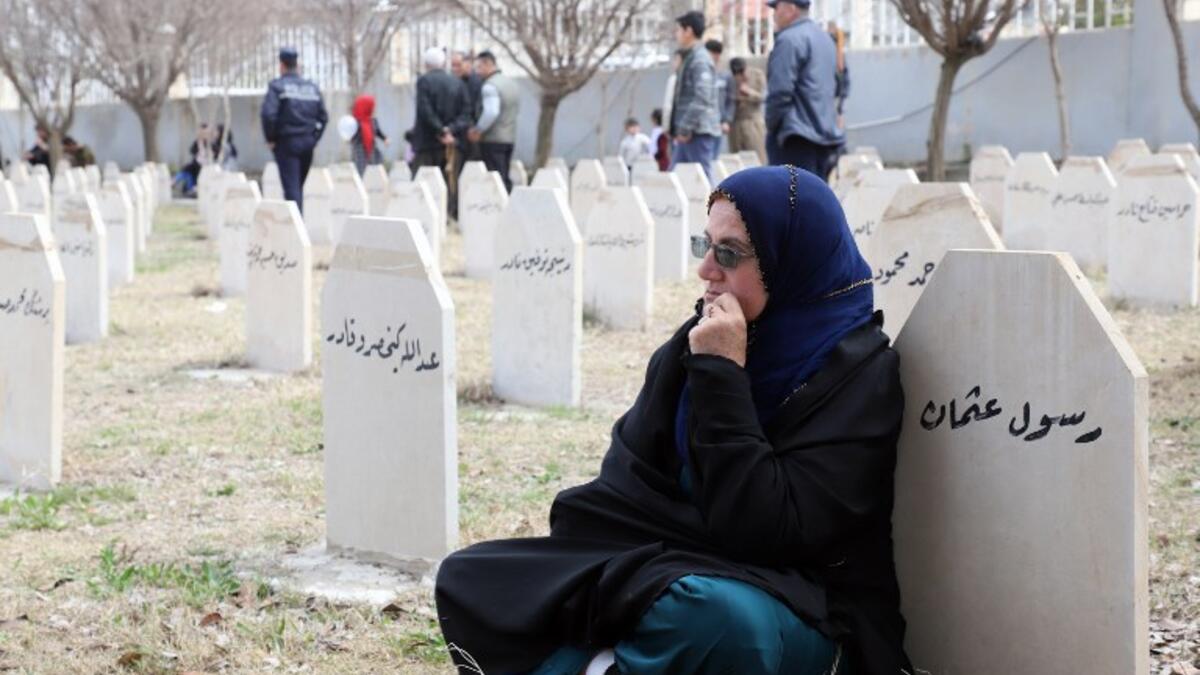 Iraqi-Kurds visit a grave site in Halabja near the monument for victims of the Halabja gas massacre 
Shwan MOHAMMED / AFP