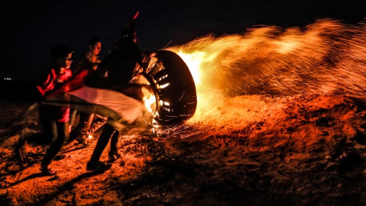 Palestinian protesters take part in a night demonstration near the fence along the border with Israel, in Rafah
SAID KHATIB / AFP