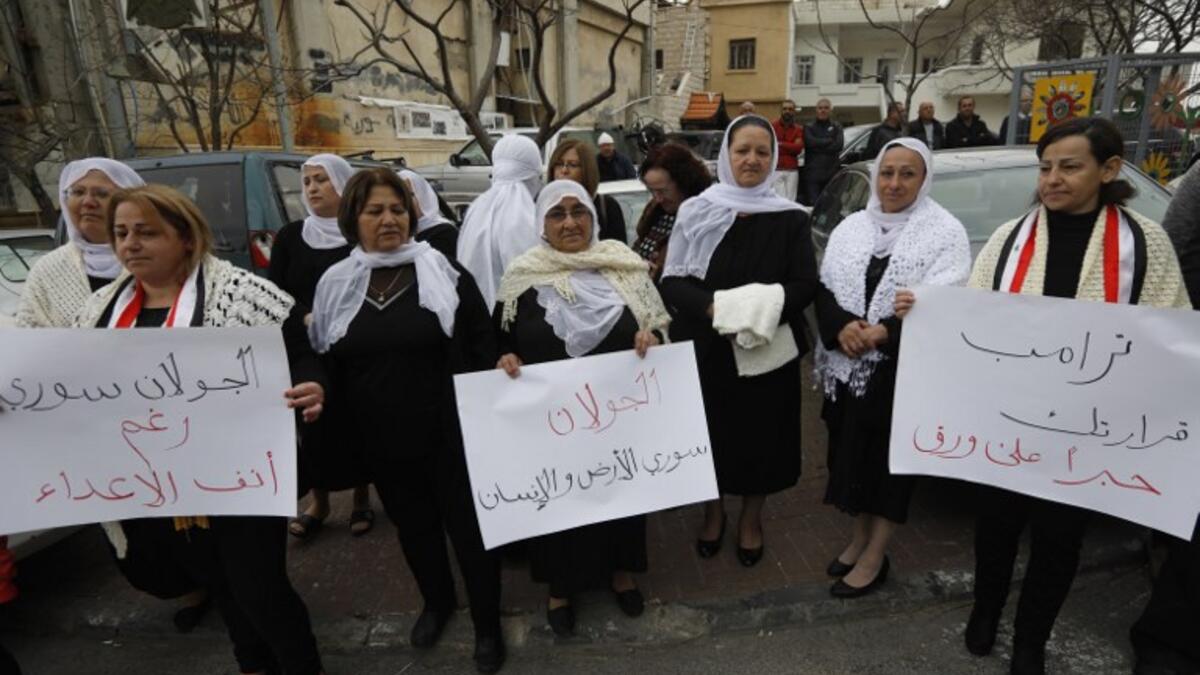 Residents of the Golan Heights raise Syrian and banners during a protest against the backing of Israel's capture of the Golan Heights by the US president, in the village of Majdal Shams in the Israeli-annexed territory on March 23, 2019.
Jalaa MAREY / AFP