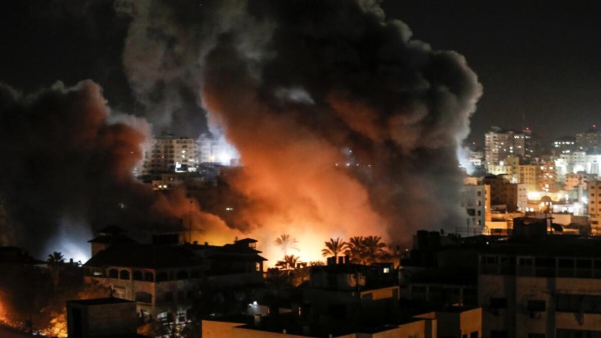 Fire and smoke billow above buildings in Gaza City during reported Israeli strikes on March 25, 2019. Israel's military launched strikes on Hamas targets in the Gaza Strip today, the army and witnesses said, hours after a rocket from the Palestinian enclave hit a house and wounded seven Israelis.
Mahmud Hams / AFP