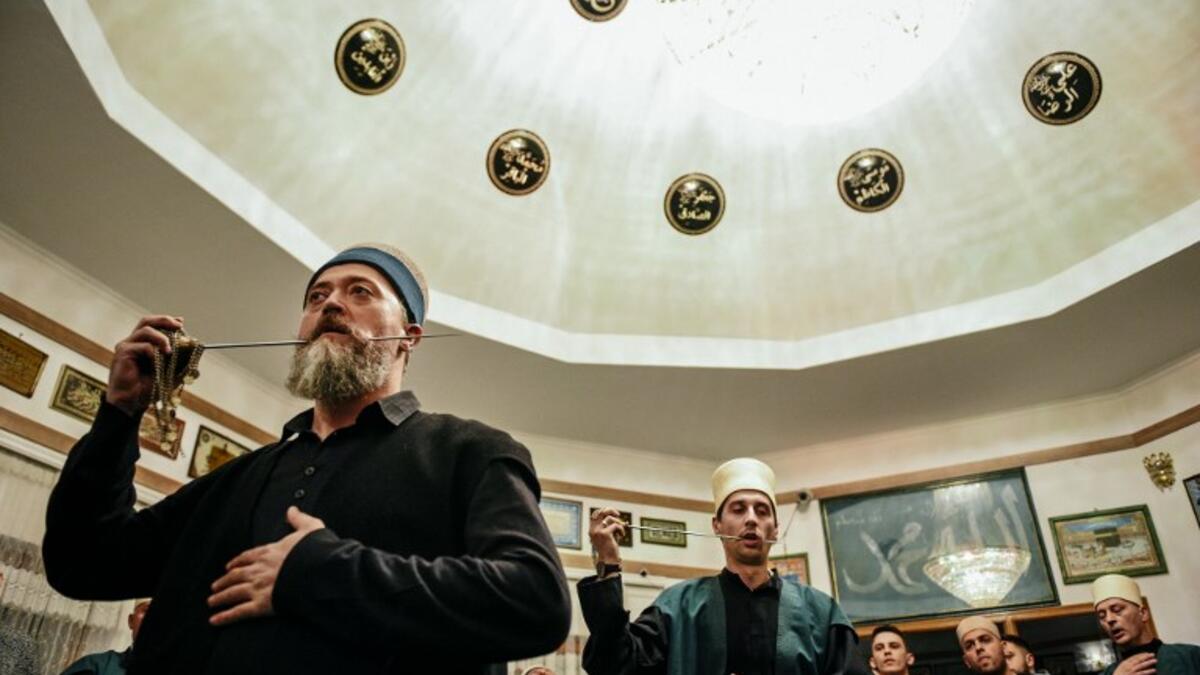 Kosovo Dervishes, adepts of Sufism, a mystical form of Islam, pierce their cheek with a needle during a ceremony in a prayer room in Gjakova
Gent SHKULLAKU / AFP