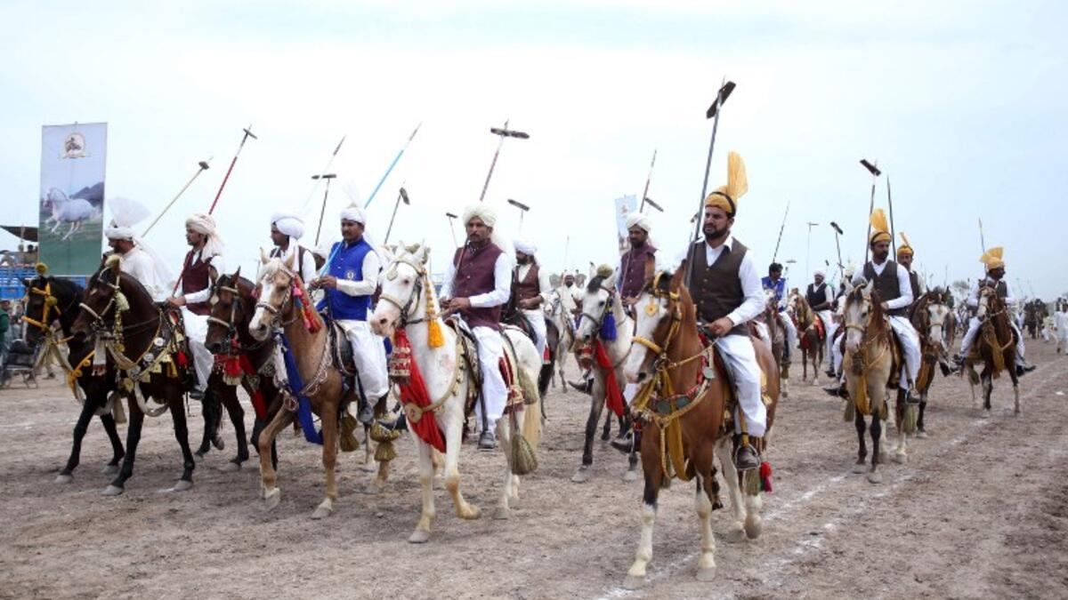 This photograph taken on March 27, 2019, shows Pakistani horse riders with lances used to pick up pegs during an attempt for a Guinness World Record for tent pegging in Khanewal district in Punjab province. 
SS MIRZA / AFP