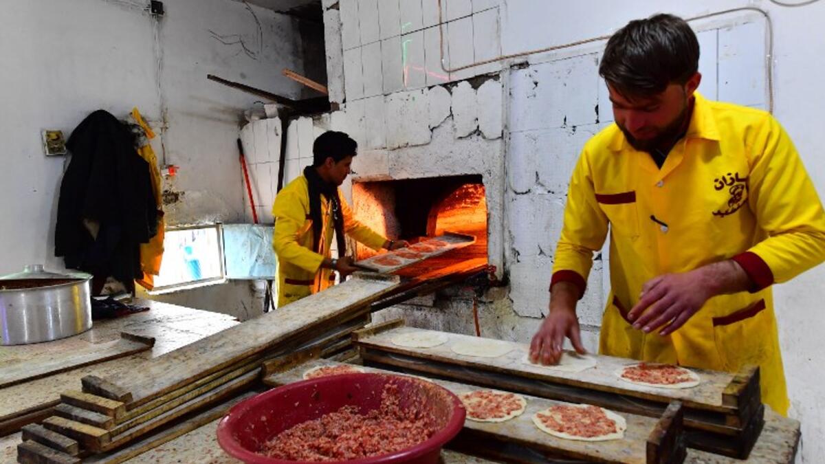 Bakers prepare local meat pies in the souk or market of Al-Hol camp for displaced people in northeastern Syria
GIUSEPPE CACACE / AFP