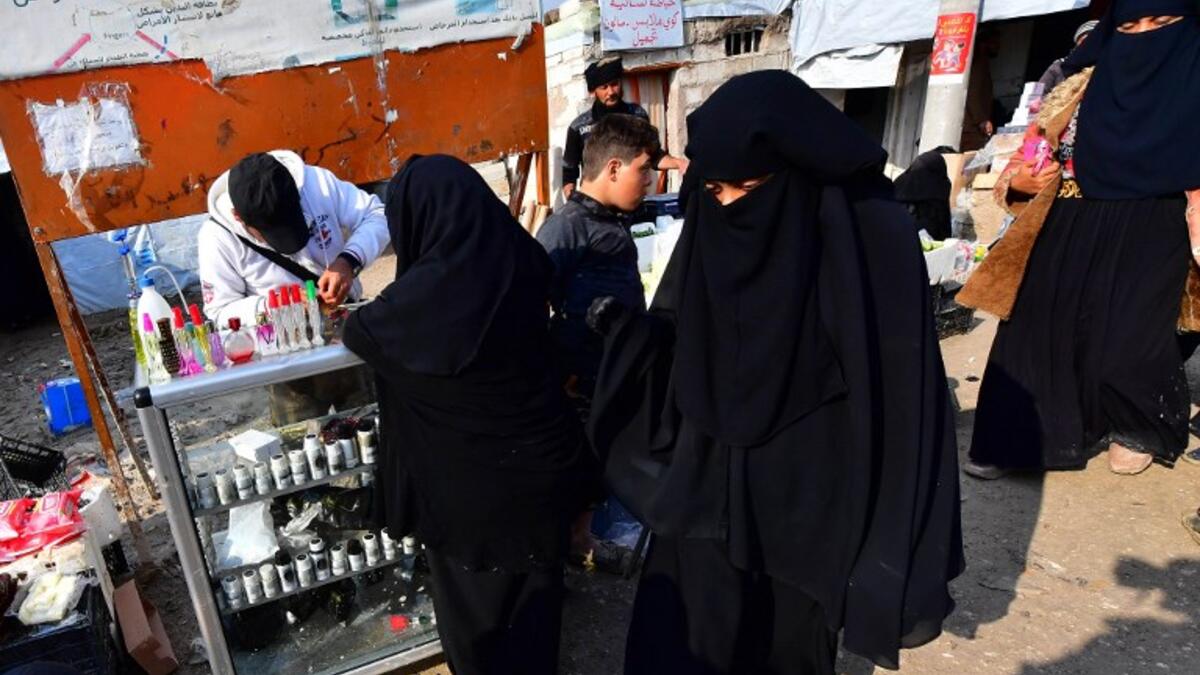 Women shop  from a stall in the souk or market of Al-Hol camp for displaced people in northeastern Syria
GIUSEPPE CACACE / AFP