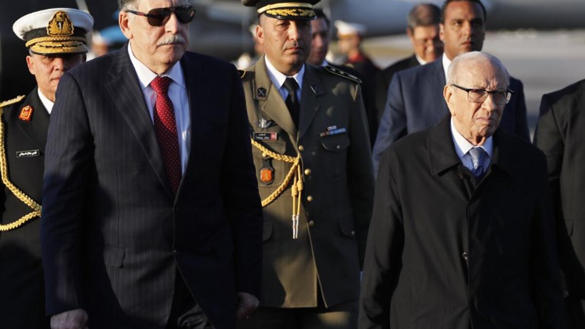 Tunisian President Beji Caid Essebsi (R) welcomes Libya's Prime Minister Fayez al-Sarraj upon his arrival at Tunis-Carthage international airport on March 30, 2019, to attend the Arab Summit tomorrow. 
Hussein Malla / POOL / AFP