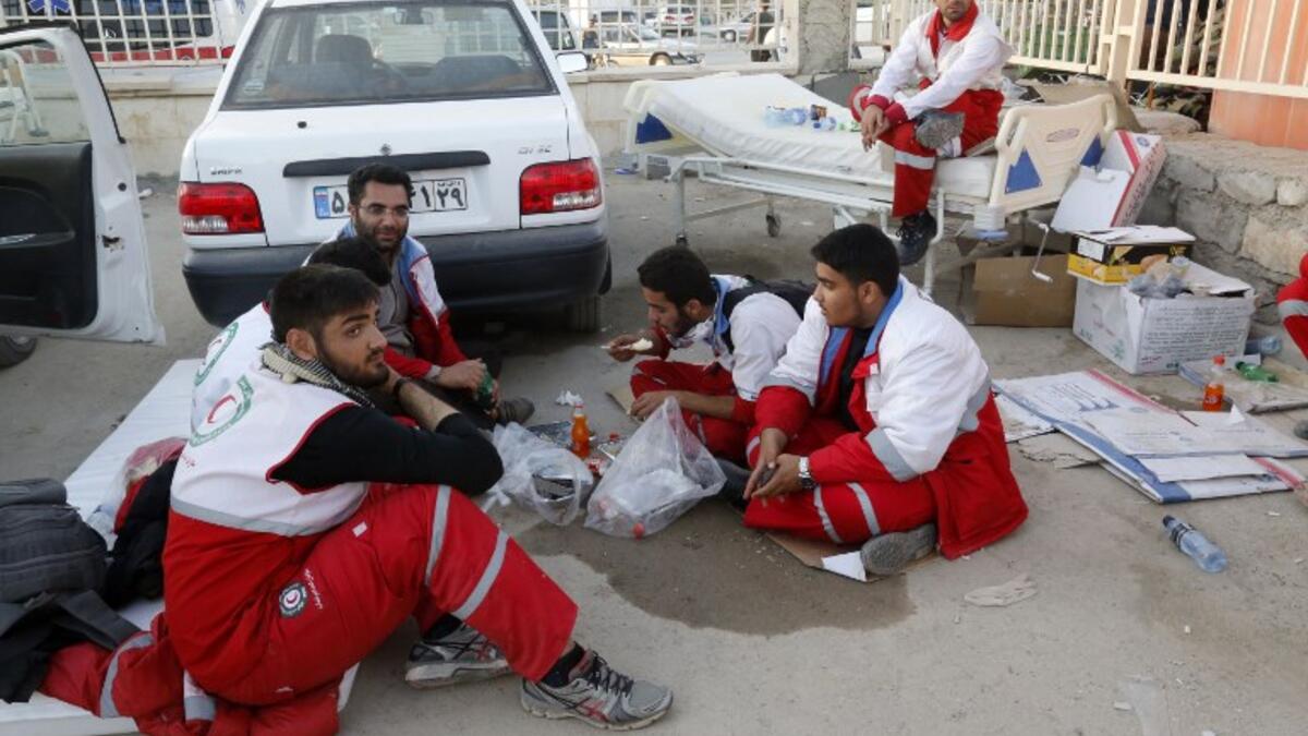 Iranian Red Crescent paramedics eat and rest during a break from tending to quake victims and survivors.

(ATTA KENARE / AFP)