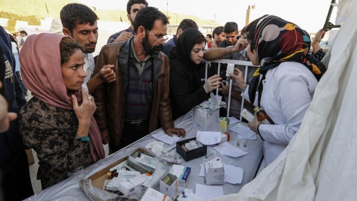 Iranian quake victims and survivors arrive to receive medical supplies at a field hospital in the town of Sarpol-e Zahab.

(ATTA KENARE / AFP)