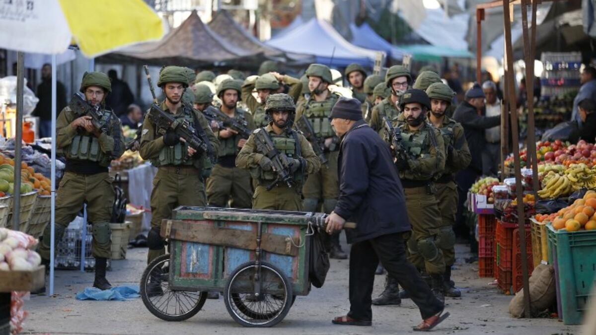 Israeli forces walk down a street during clashes with Palestinian demonstrators in Hebron in the Israeli-occupied West Bank on Dec. 9, 2017, following the US president's controversial recognition of Jerusalem as Israel's capital. 
(HAZEM BADER / AFP)