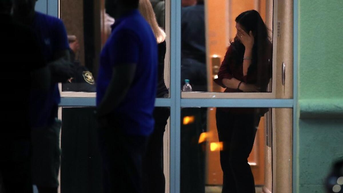 People gather at a hotel where students were quickly taken after a mass shooting at the Marjory Stoneman Douglas High School on Feb. 14, 2018 in Parkland, Florida. 
(MARK WILSON / GETTY IMAGES NORTH AMERICA / AFP)