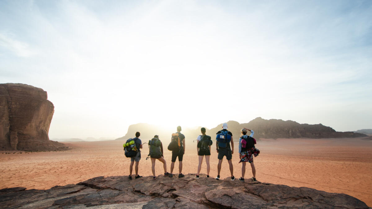 Tourist friends on a top of mountains in a desert. Sunset view. Nature. Tourist people enjoy a moment in a nature. Wadi rum national park - Jordan (Shutterstock/File Photo)