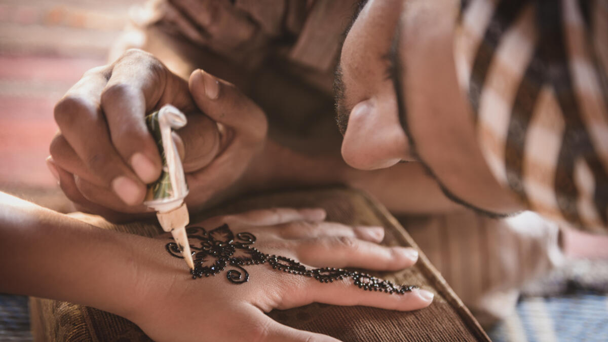 Bedouin making henna on a woman's hand. Hand decorations are usually done by a relative of the bride in her home (Shutterstock/File Photo)
