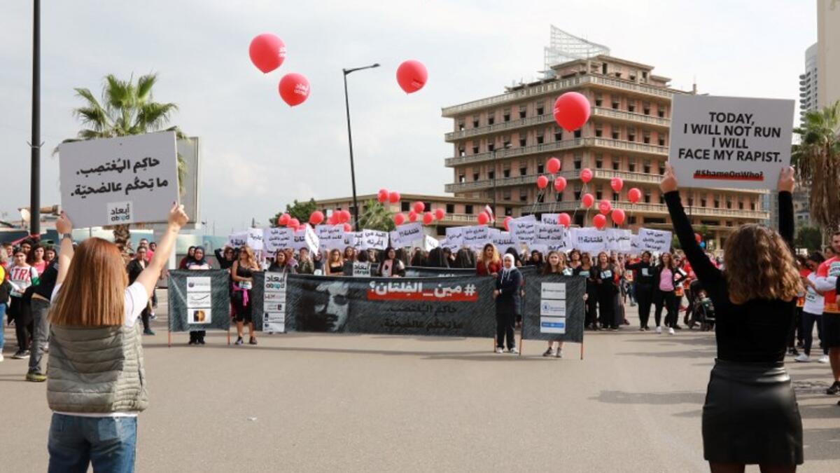 Activists hold banners against sexual assaults during the 16th edition of the Beirut Marathon on November 11, 2018. 
ANWAR AMRO / AFP