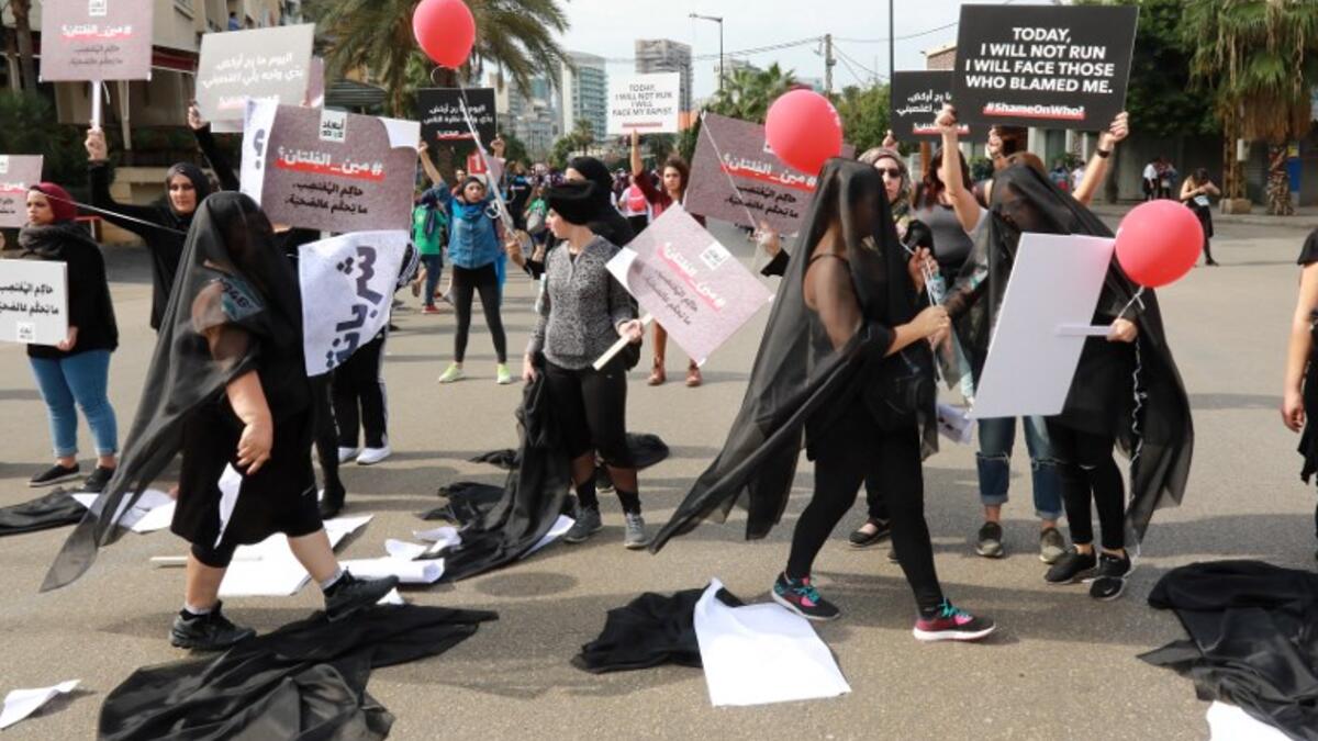 Activists hold banners against sexual assaults during the 16th edition of the Beirut Marathon on November 11, 2018. 
ANWAR AMRO / AFP