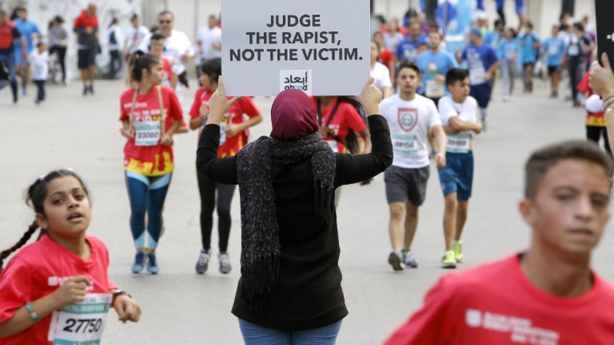 A protester holds a banner with a message against sexual assault during the 16th edition of the Beirut Marathon in the Lebanese capital on November 11, 2018. 
Marwan TAHTAH / Abaad / AFP