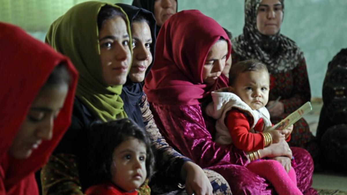 Women and young girls listen to Rasul, an Iraqi Kurdish activist with the non-profit organisation WADI, as she peaks about the harms of genital mutilation in Sharboty Saghira, a small village east of regional capital Arbil.
SAFIN HAMED / AFP
