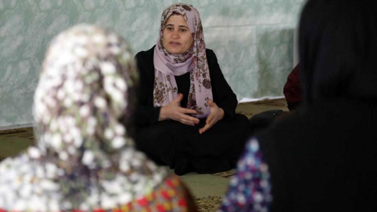 Rasul (C), an Iraqi Kurdish activist with the non-profit organisation WADI, speaks to women and young girls about the harms of genital mutilation in Sharboty Saghira.
SAFIN HAMED / AFP
