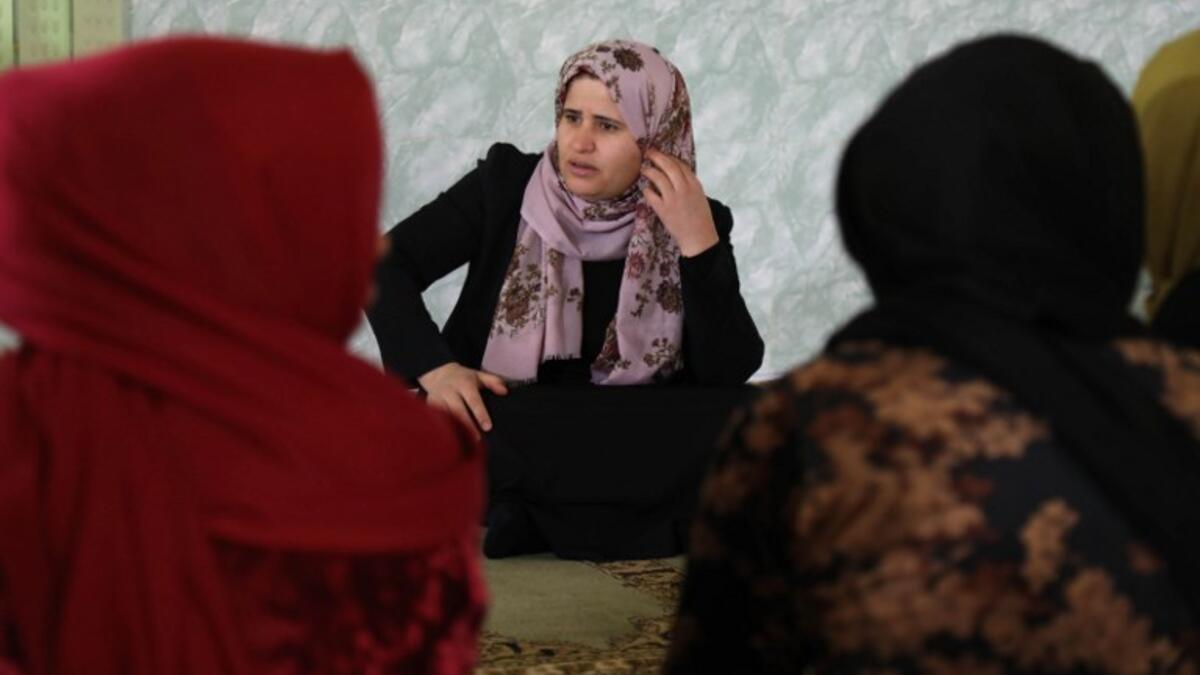Rasul (C), an Iraqi Kurdish activist with the non-profit organisation WADI, speaks to women and young girls about the harms of genital mutilation in Sharboty Saghira.
SAFIN HAMED / AFP
