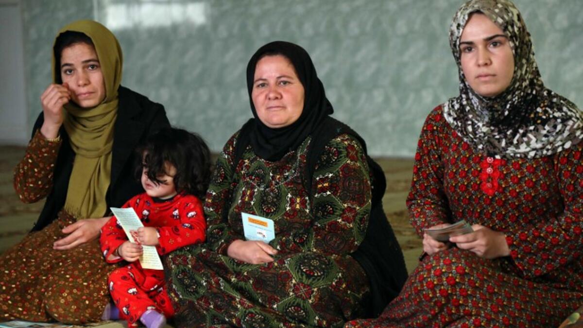 Women and young girls listen to Rasul (not pictured), an Iraqi Kurdish activist with the non-profit organisation WADI, as she peaks about the harms of genital mutilation in Sharboty Saghira.
SAFIN HAMED / AFP