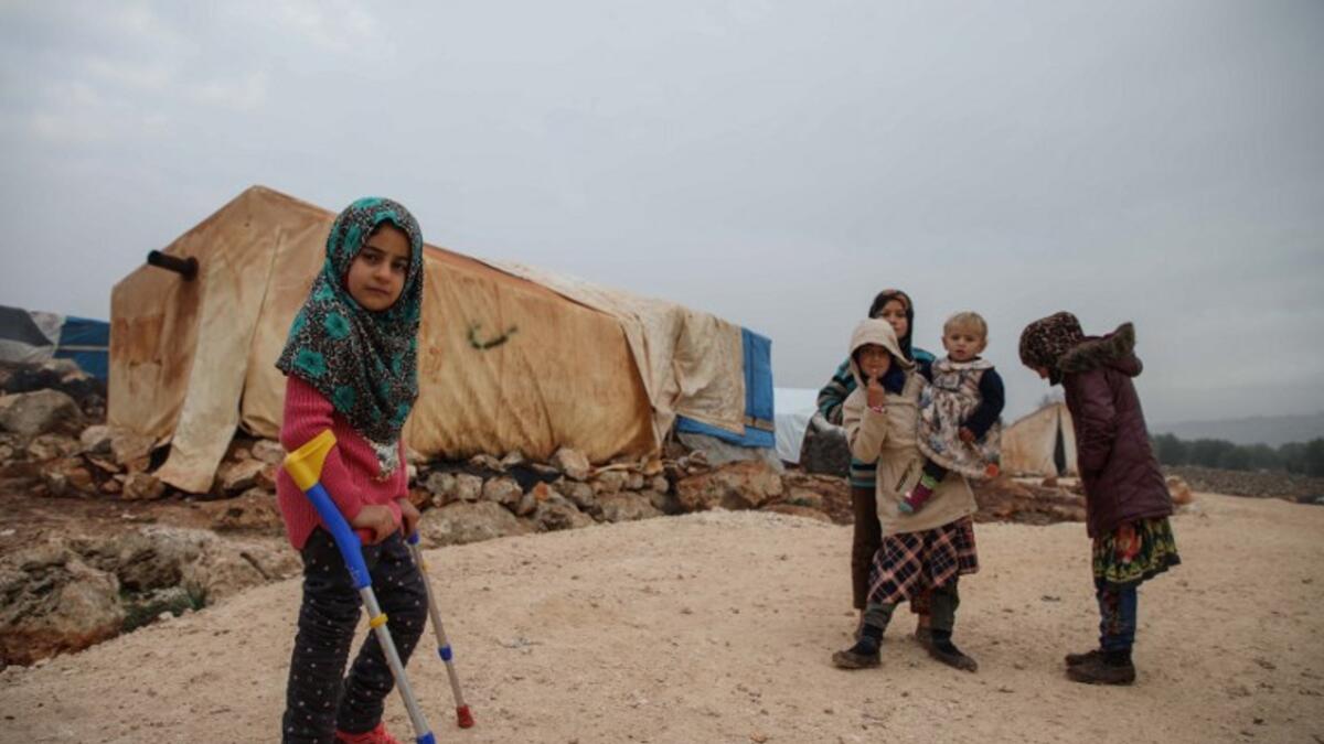 Syrian Maya Merhi poses for a picture next to her prosthetic legs that are decorated with the Turkish flag inside a tent at the Internally Displaced Persons (IDP) camp of Serjilla in northwestern Syria. 
Aaref WATAD / AFP