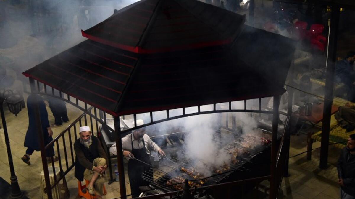 Pakistani man cooks grilled meat on a barbeque at the Charsi (Hashish) Tikka restaurant in Namak Mandi in Peshawar.
ABDUL MAJEED / AFP