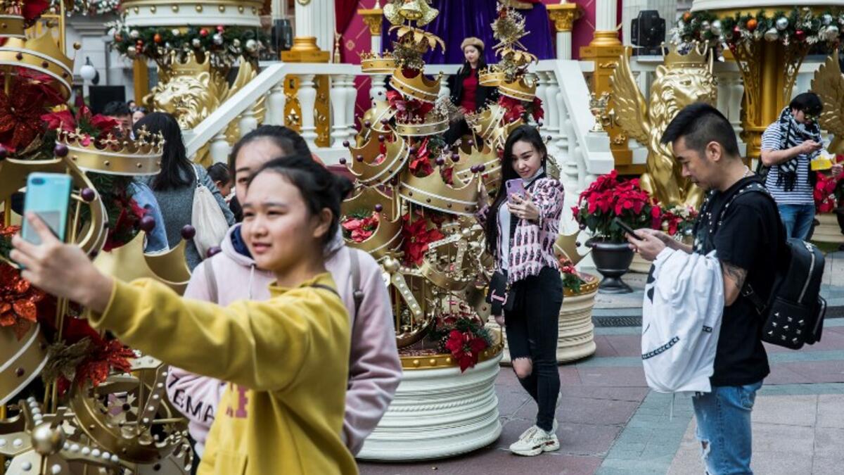 People take photos in front of Christmas decorations on display in the Kowloon district of Hong Kong on December 16, 2018. 
ISAAC LAWRENCE / AFP
