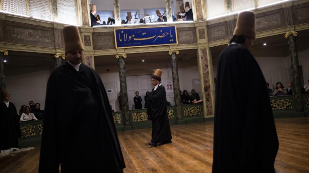 People look at whirling dervishes performing during a ceremony marking the anniversary of the death of Jelaleddin Mevlana Rumi, Sufi mystic, poet and founder of the sufism on December 16, 2018 at Galata Mevlihanesi in Istanbul. 
Yasin AKGUL / AFP