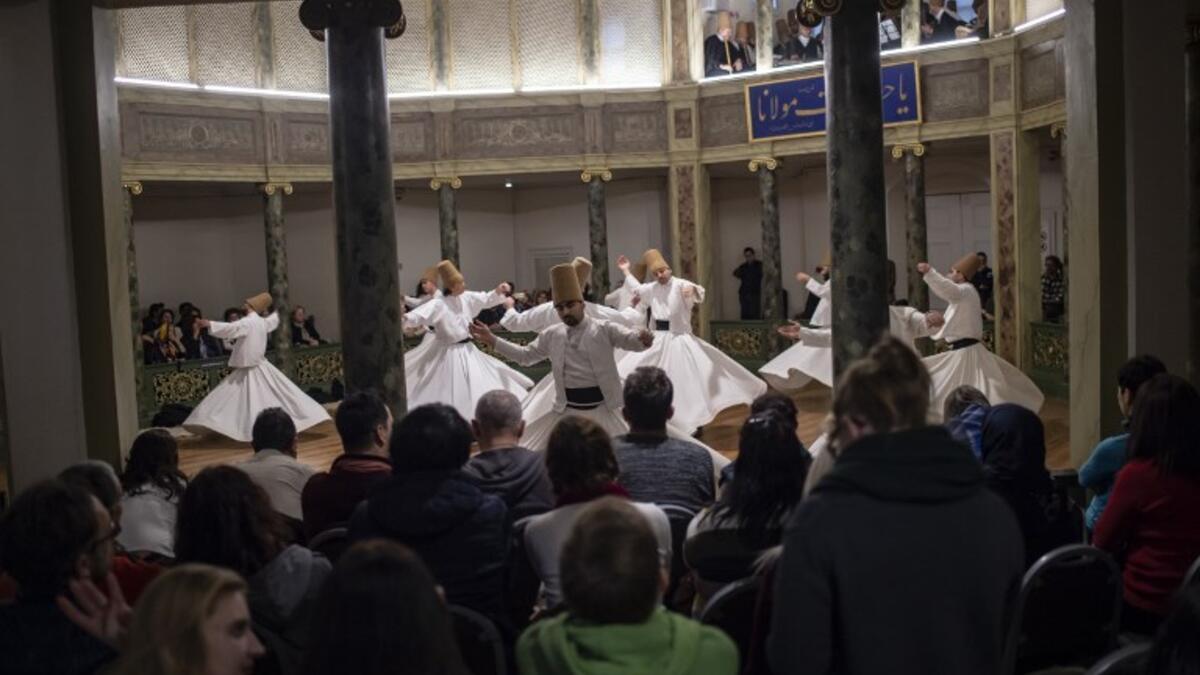 People look at whirling dervishes performing during a ceremony marking the anniversary of the death of Jelaleddin Mevlana Rumi, Sufi mystic, poet and founder of the sufism on December 16, 2018 at Galata Mevlihanesi in Istanbul. 
Yasin AKGUL / AFP
